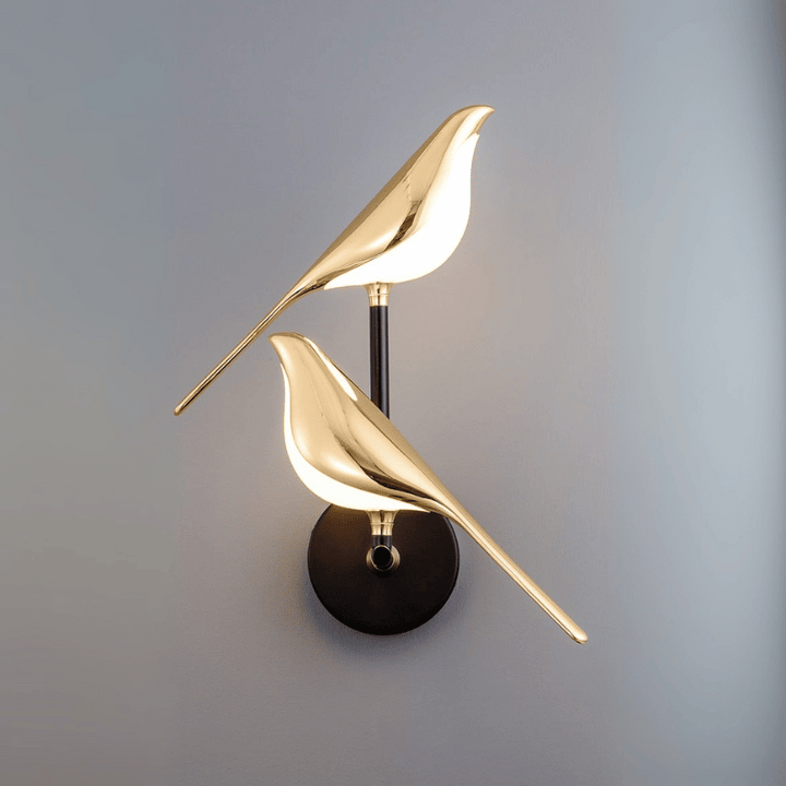 Gold LED wall light with magnetic bird design