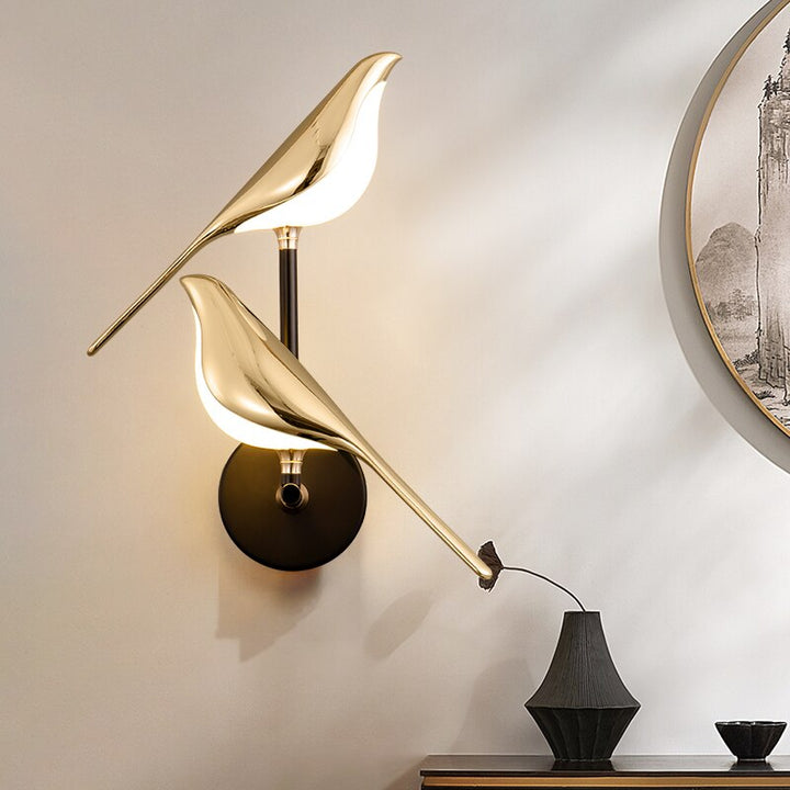 Gold LED wall light with magnetic bird design