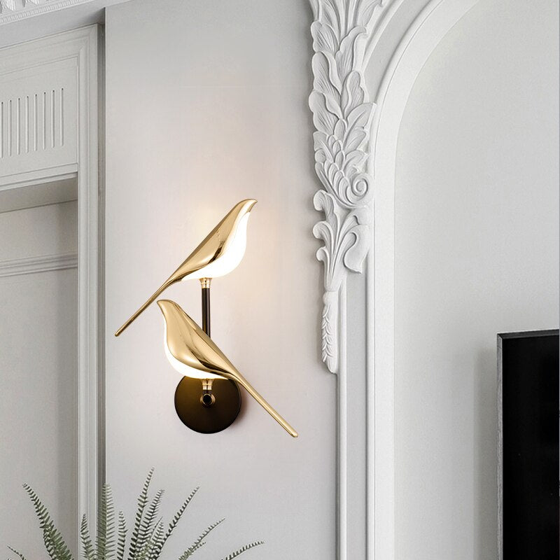 Gold LED wall light with magnetic bird design