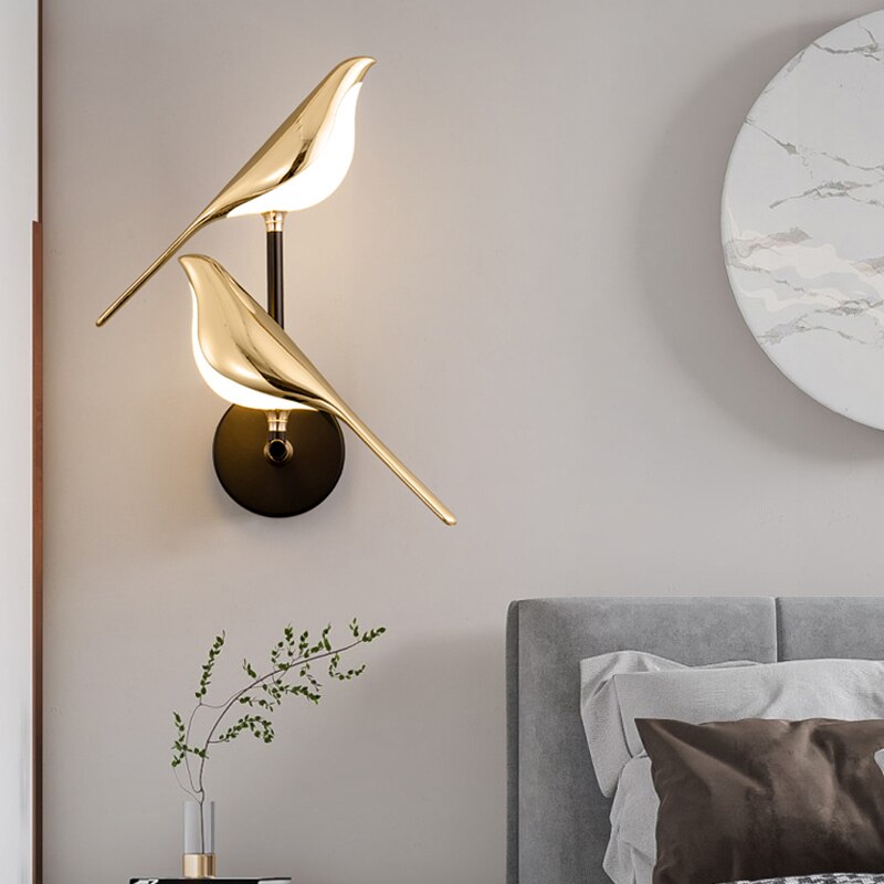 Gold LED wall light with magnetic bird design